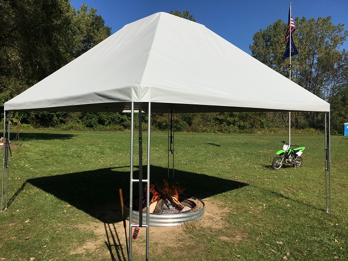 a fire pit under a canopy in an open field